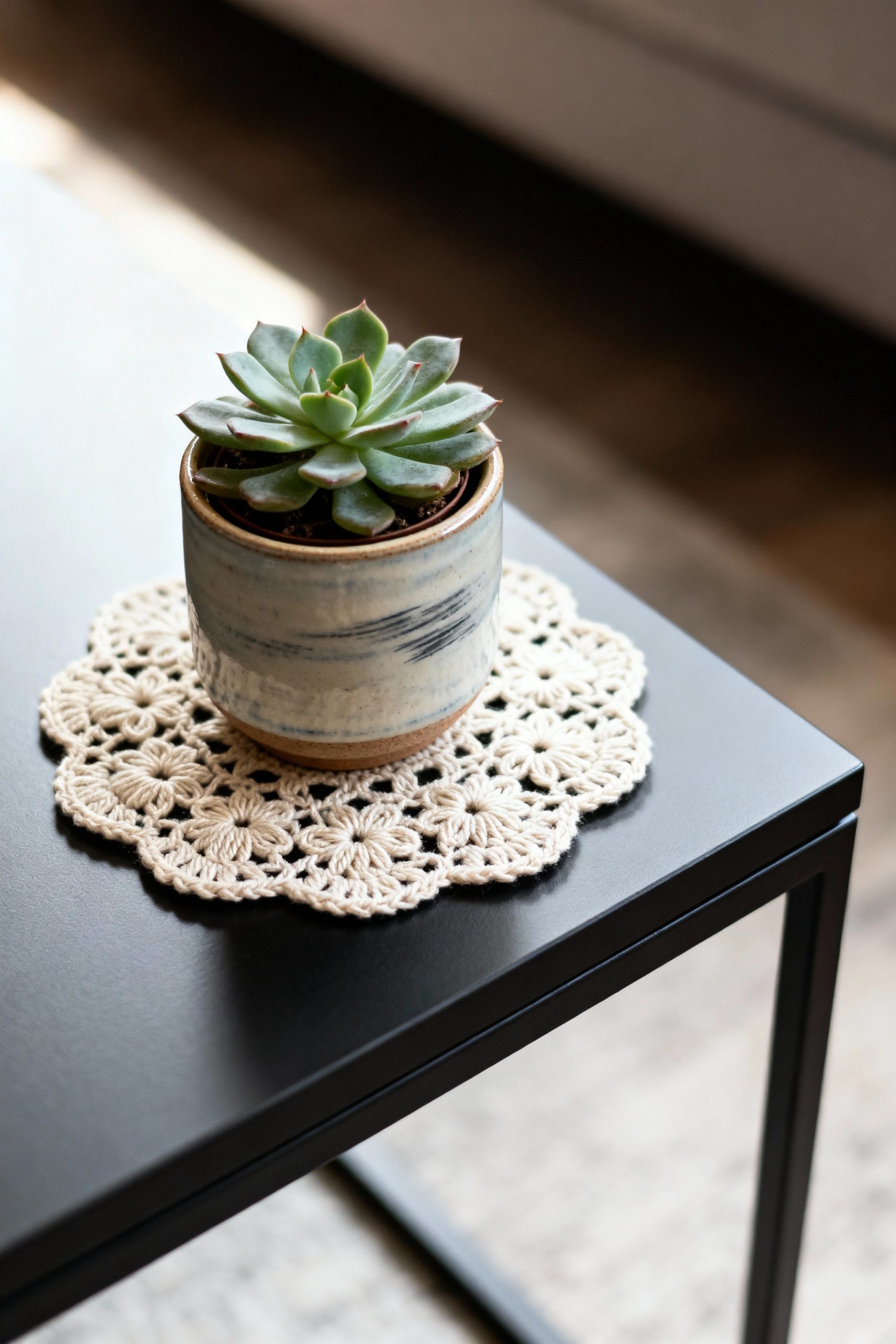 A close-up of a small plant in a ceramic pot sitting on a round lace doily, contrasting beautifully with the sleek surface of a modern side table.