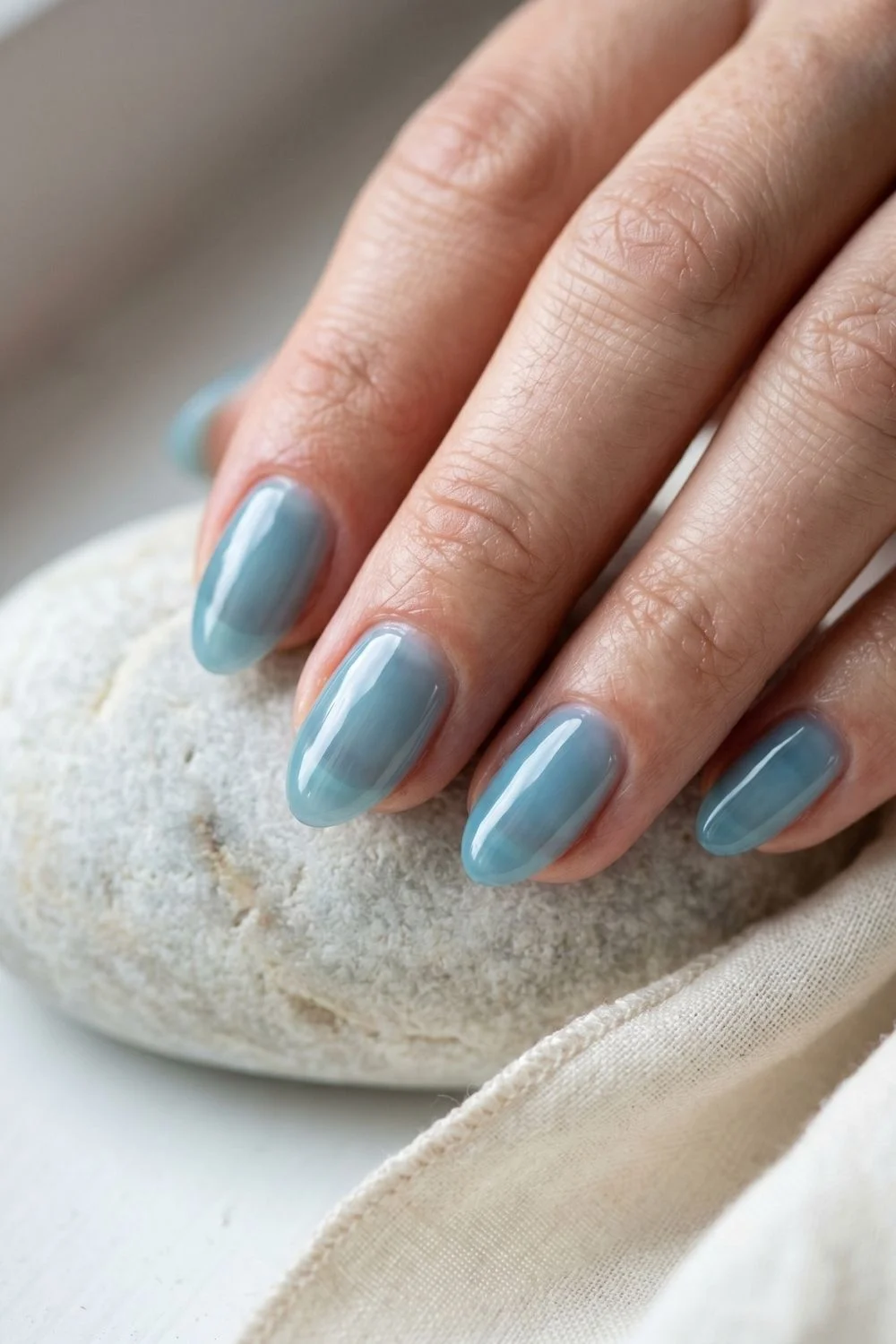 Sea-Glass Blue Jelly Nails: Summer 2026's Coastal-Calm Manicure 1 Macro view of translucent sea-glass blue jelly polish on short almond nails