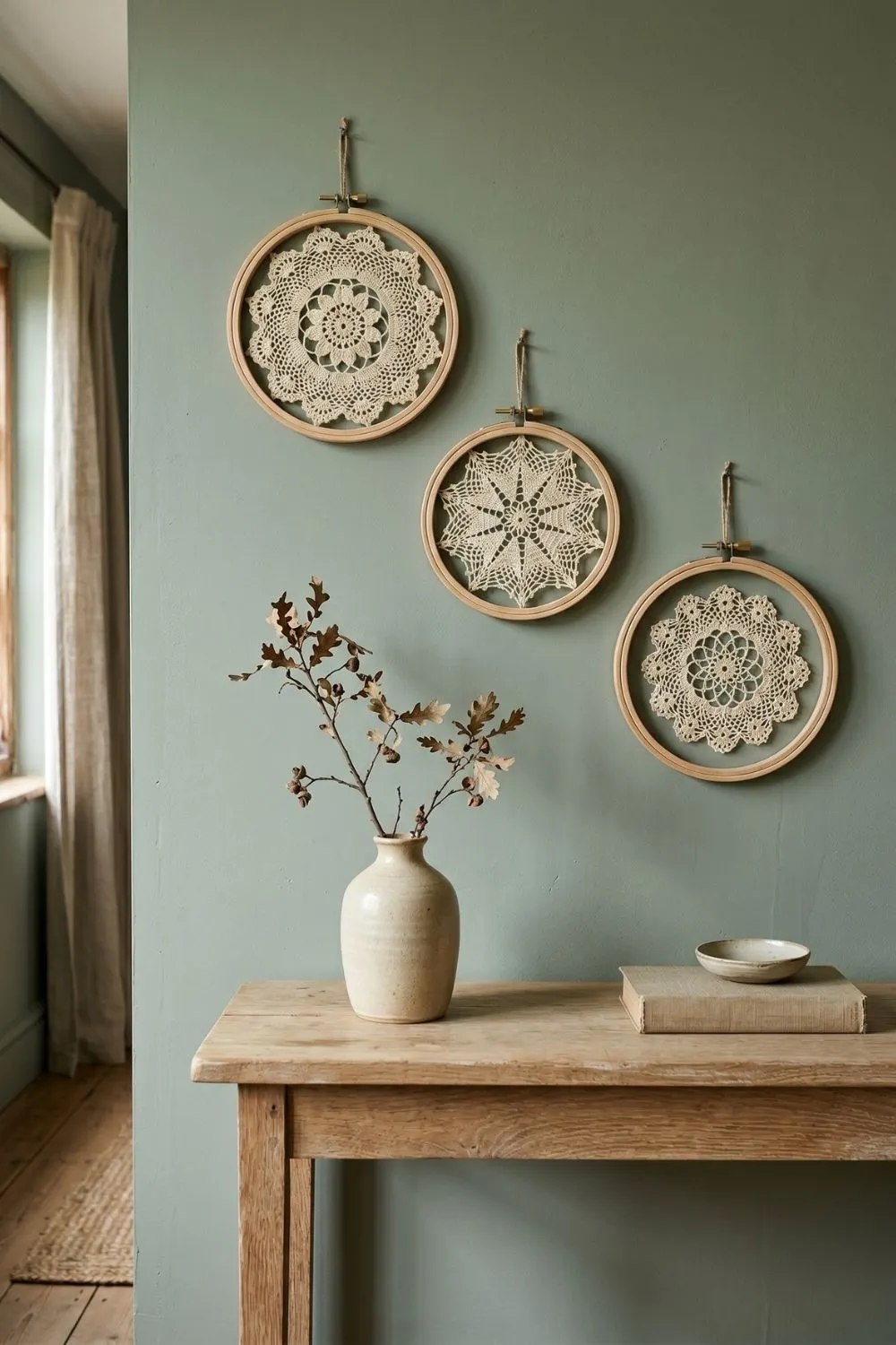 Three embroidery hoops framing antique crochet doilies, displayed as a small gallery wall above a console table