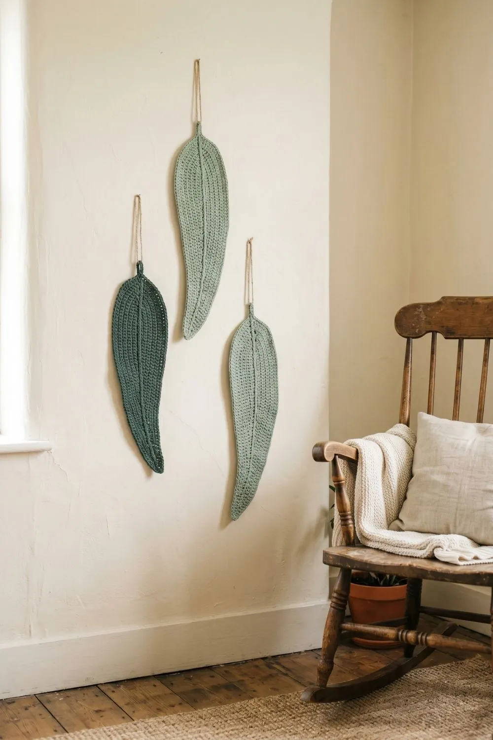 8 Crochet Wall Hanging Ideas for a Calm Nursery Corner: Soft Designs Worth Saving 4 Three crochet eucalyptus leaf wall hangings arranged on a cream wall