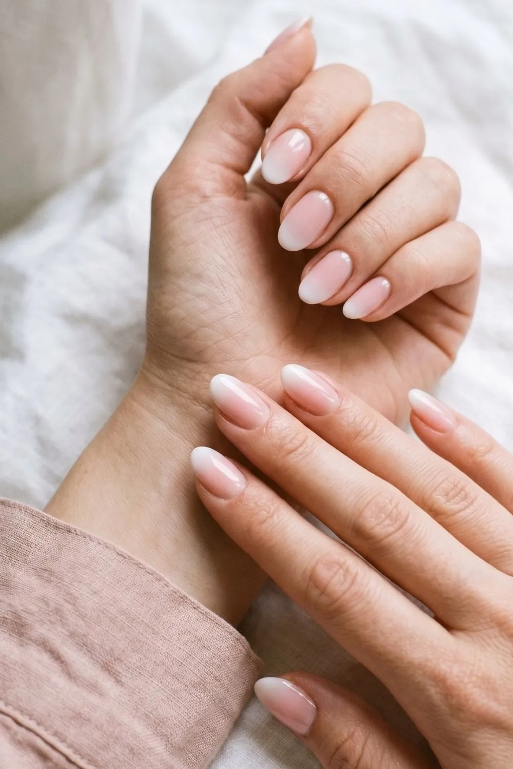 6 Modern French Tip Nail Variations Everyone Is Asking for Right Now 3 Close-up of oval nails with a soft pink to white ombre gradient French tip effect