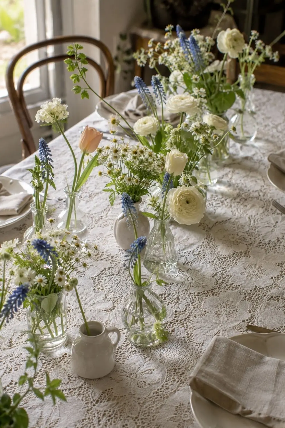 Lace Tablecloths Are Back—But the Fresh Spring Table Trick Is the Layer Underneath 3 Low spring flowers in small vessels arranged down the centre of a lace tablecloth
